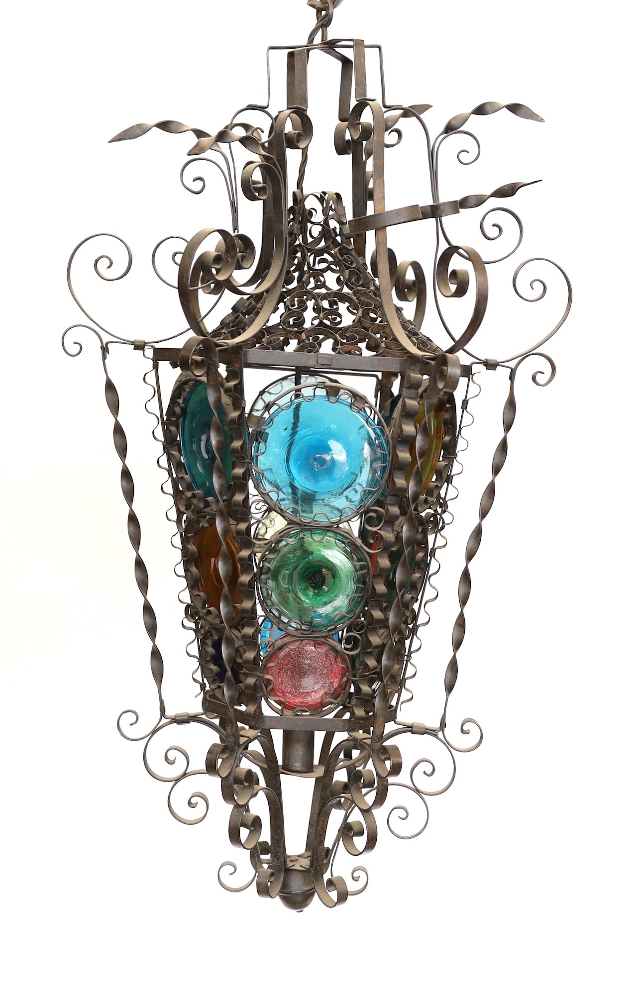 An early 20th century French wrought iron and coloured glass lantern of tapering hexagonal form, height 80cm. width 50cm